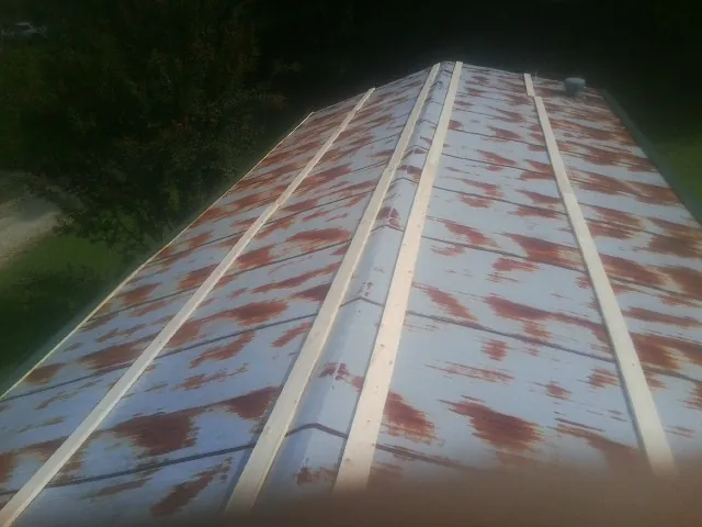 Rusted metal roof panels with new wood purlins before replacement — Storm Damage Roof Repair in Deansboro by Roofing Brothers