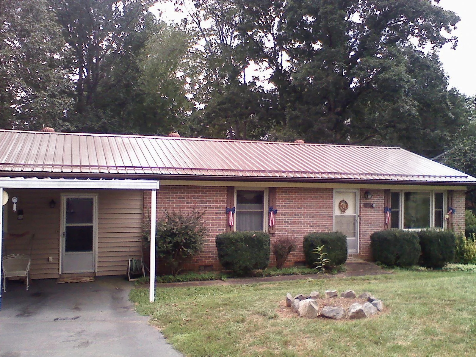 Bronze metal roof and carport on a brick ranch home in Deansboro